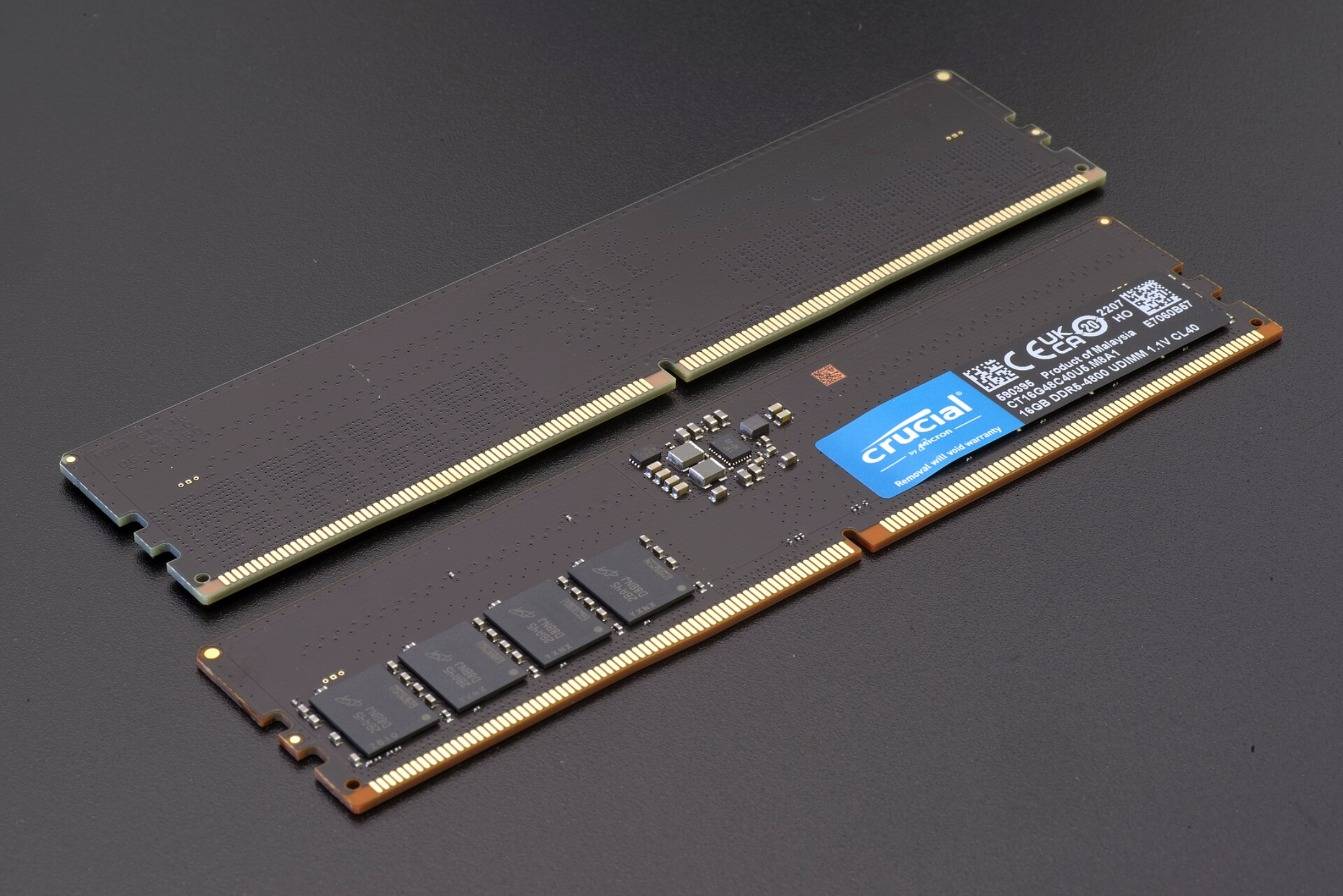 Two DDR5 memory modules on a dark surface