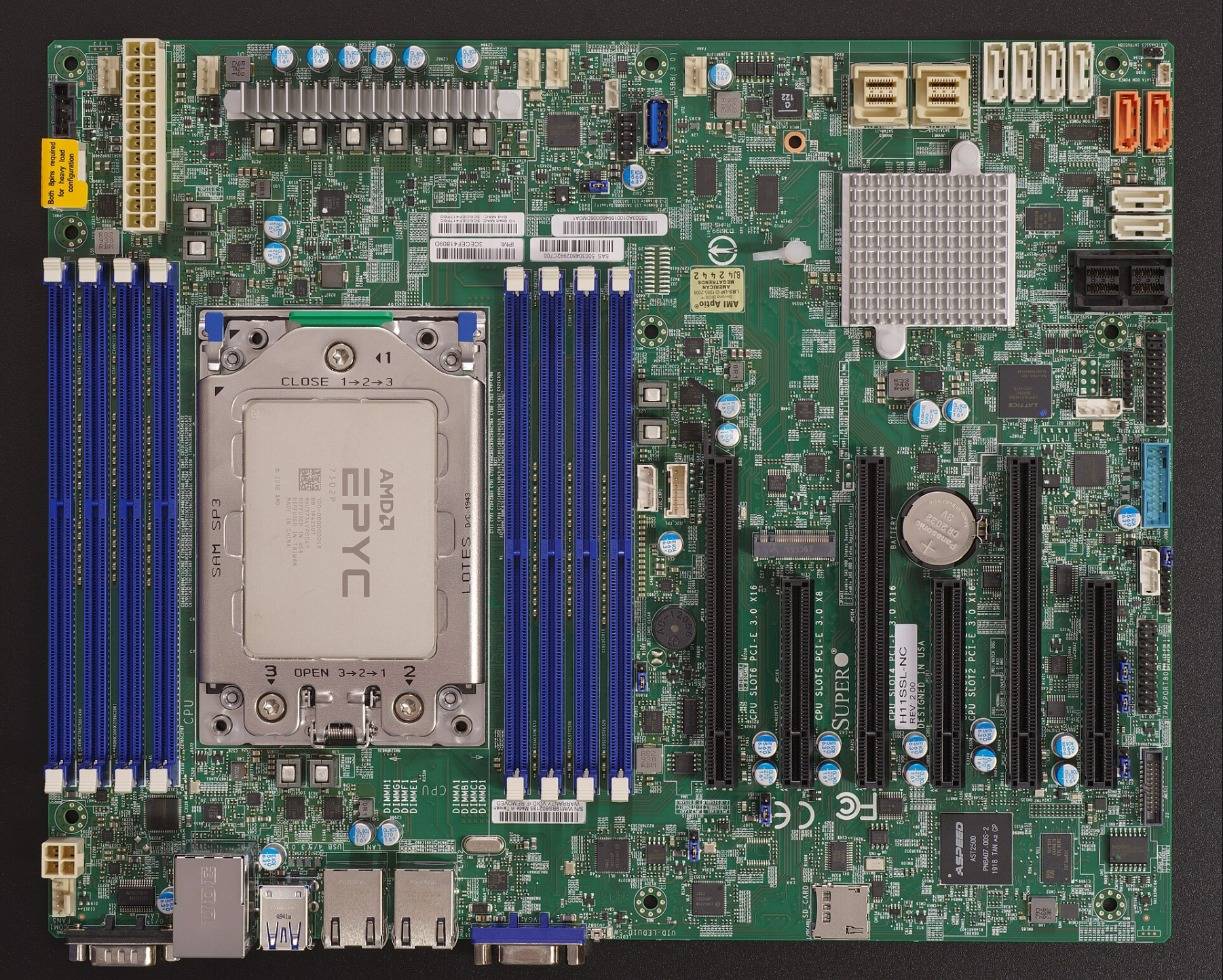 An AMD EPYC server board with eight DIMM slots around the CPU socket and PCIe slots below
